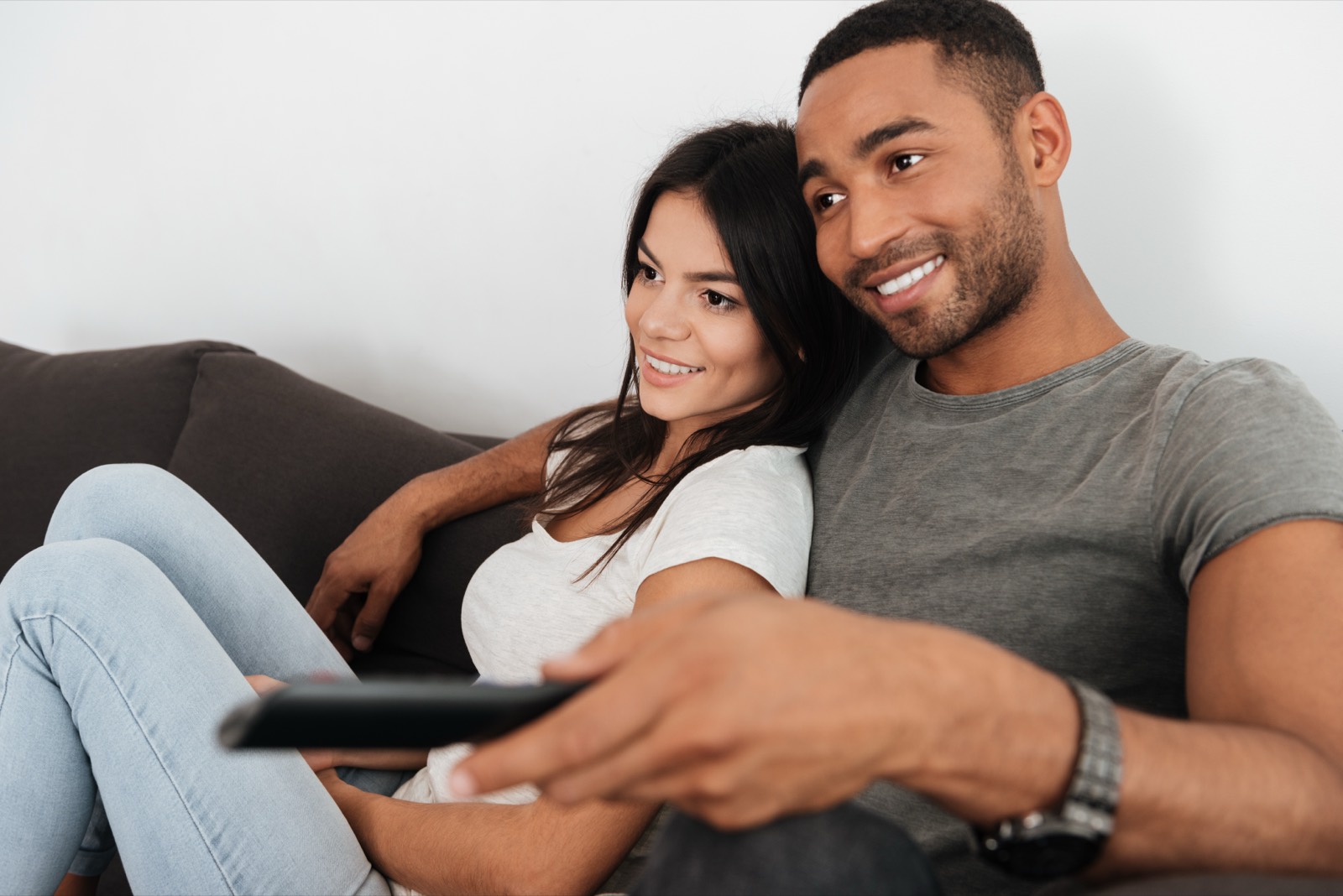 A couple watching streaming TV on the sofa at home